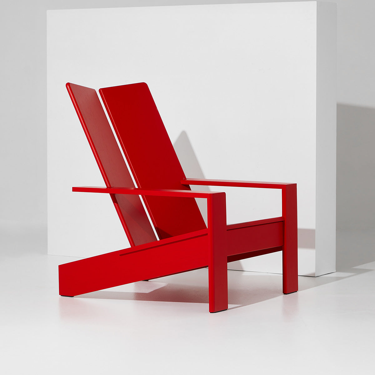 A bright red minimalist AD11 outdoor chair with a sleek, angular design positioned against a white background.